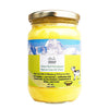 An image depicting a glass jar of Urbana Superfoods Grass-Fed Himalayan Native Cow A2 Ghee, filled with bright yellow granulated ghee, featuring mountain peaks and a cow illustration on the label, symbolising purity, Himalayan sourcing, and traditional handmade preparation.